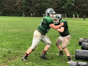 Newfield has embraced the eight-player lineup as recent participation numbers in football fell. Here, Cian Howell and Kyler McIlroy work on drills.