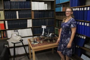 Ponterio stands with a model of one of the Mars explorers, a NASA project that she worked on, that sits on display at the SPIF facility among the archives of the many images taken from space.