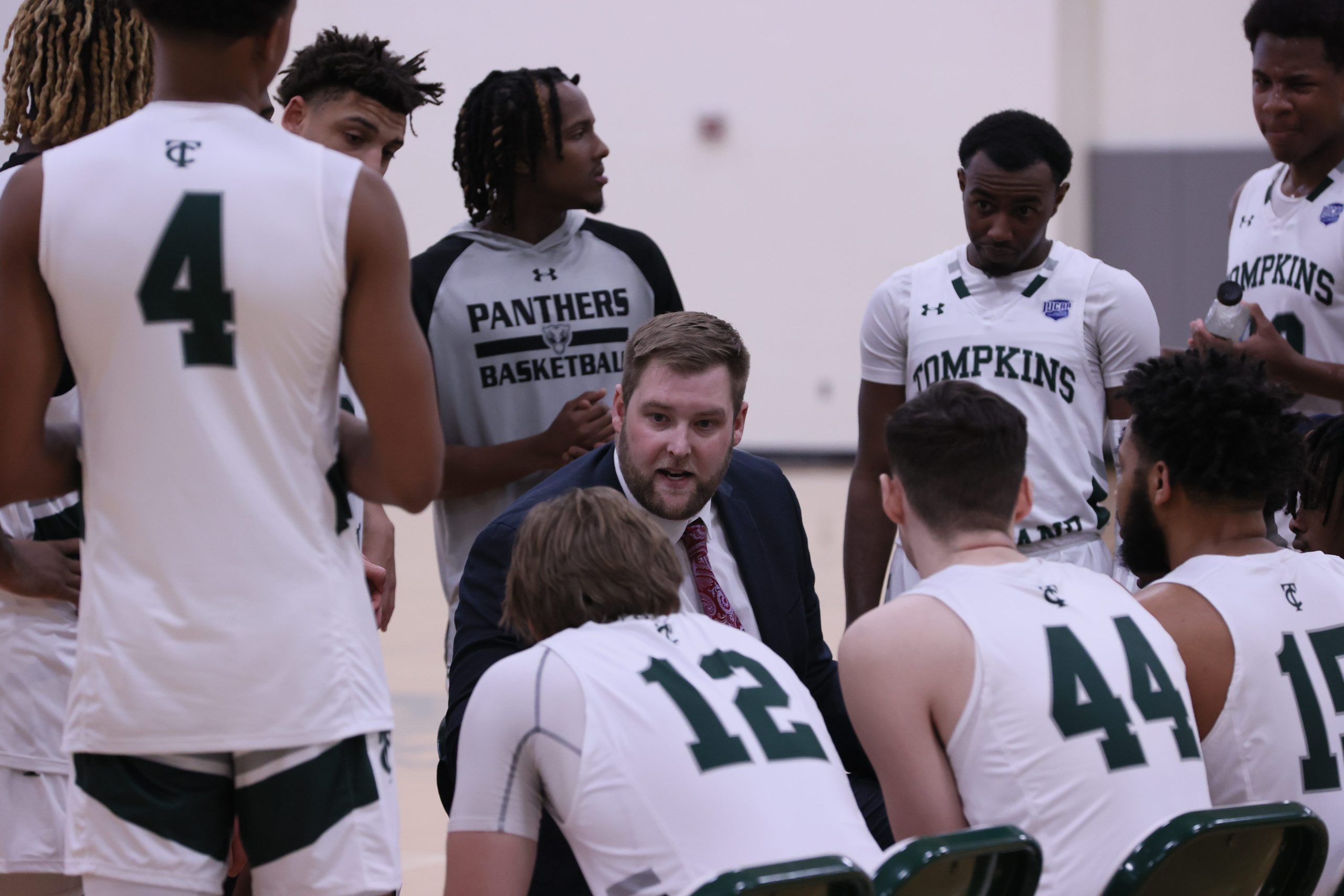 The TC3 Panthers and their coaches in a huddle