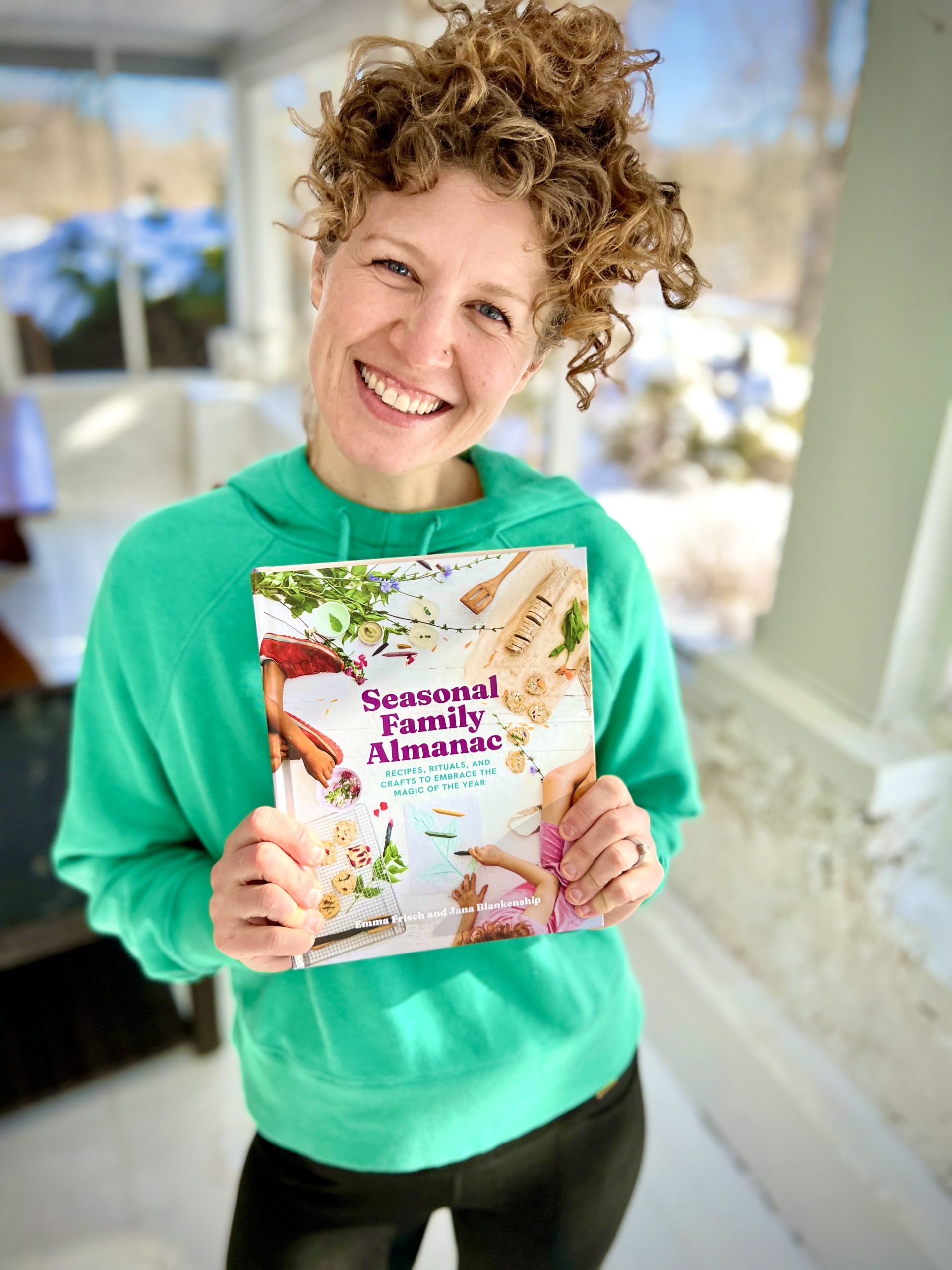 Emma Frisch holding the book she recently co-published