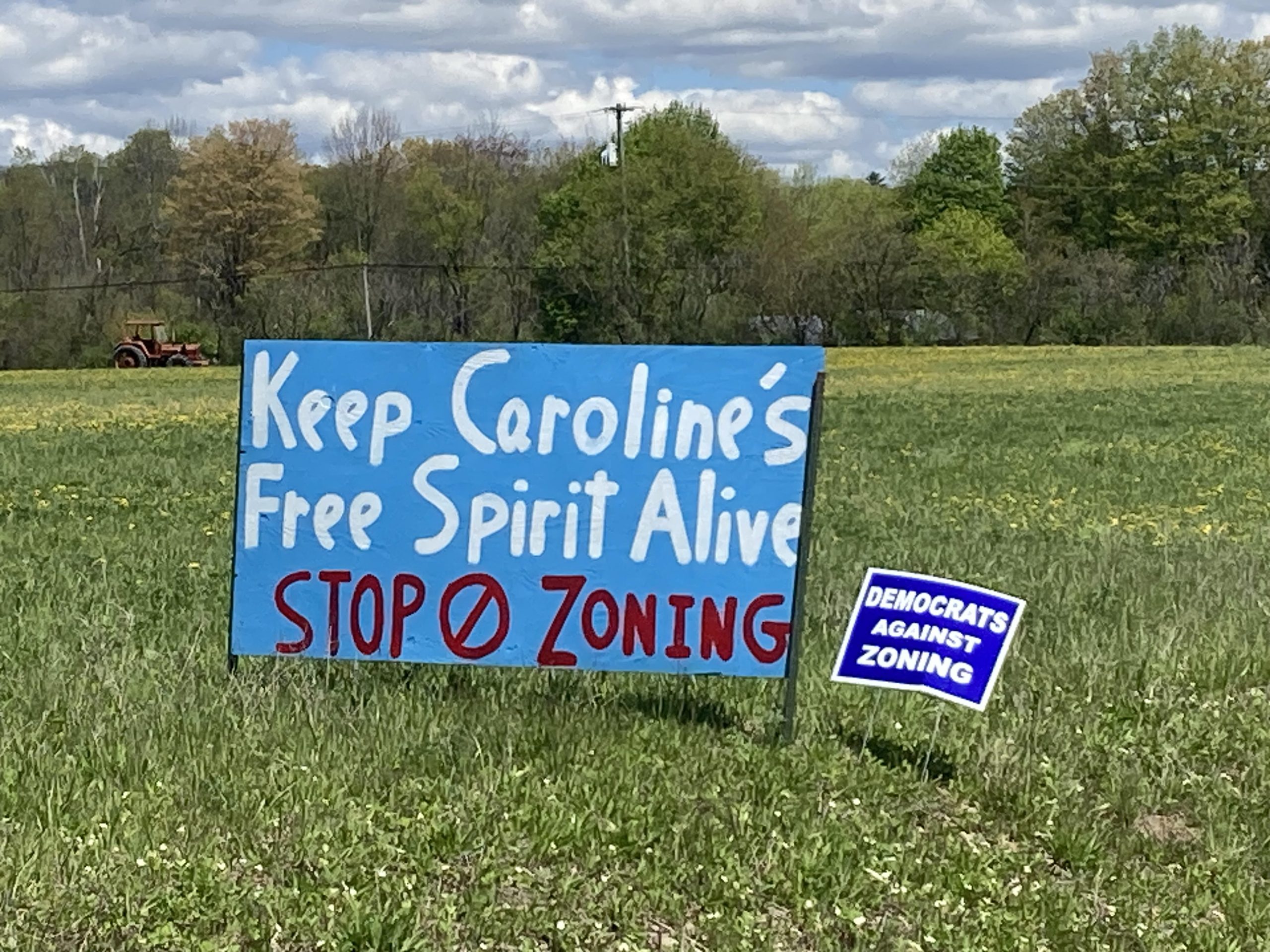 An anti-zoning sign in a field off of New York State Route 79, with a Democrats Against Zoning sign next to it. The Tompkins County Democratic Committee is calling for a criminal investigation into Republicans from Caroline changing their party affiliation to vote in the June 27 Town Board primary.