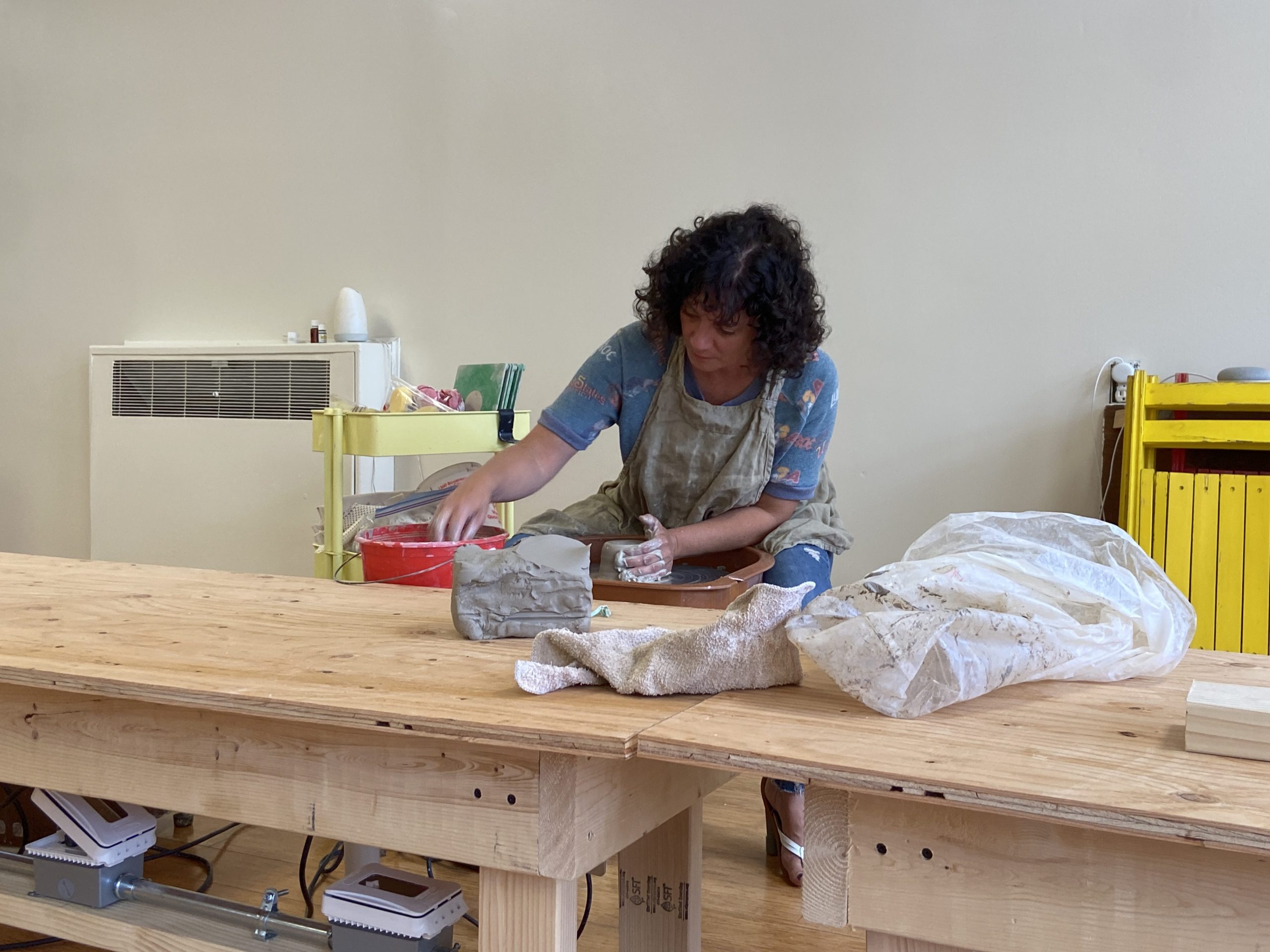 Beth cutting clay while working in her studio.
