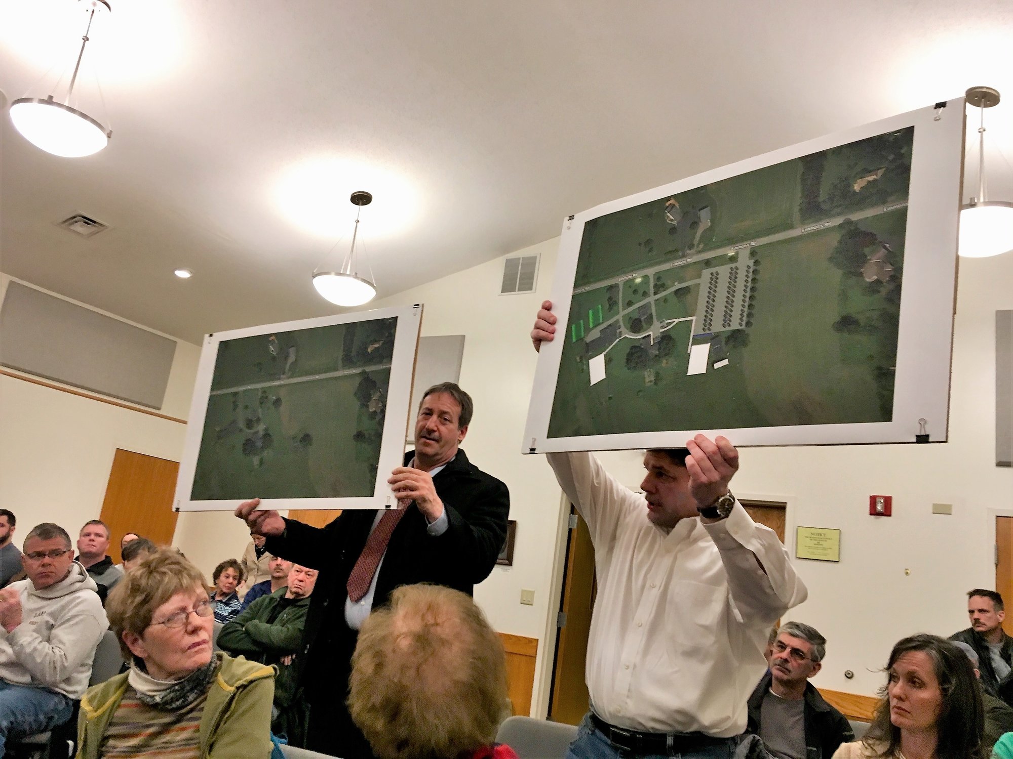 Richard Mule’ (left) and Eric Van Every hold up “before and after” images of the planned “Osmica at Spring Trail Farm” bed and breakfast and wedding venue on Emmons Road during the public comment portion of the Feb. 25 Town Zoning Board meeting. Due to changes in Osmica’s application, more public comment will be heard at the next Zoning Board meeting March 11 at 6:30 p.m.