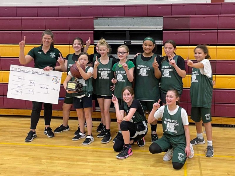 The Lil' Trojans 5th and 6th grade recreational basketball team with their trophy and bracket poster