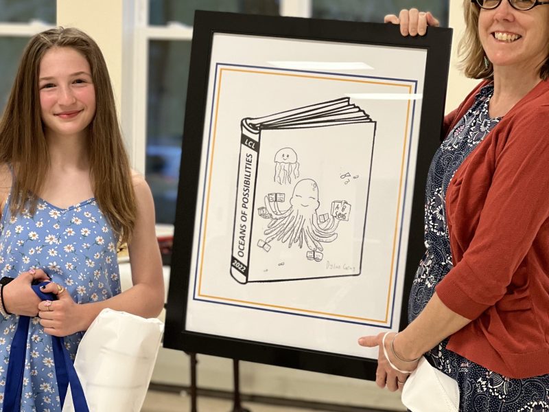 the contest winner with the library manager and her design