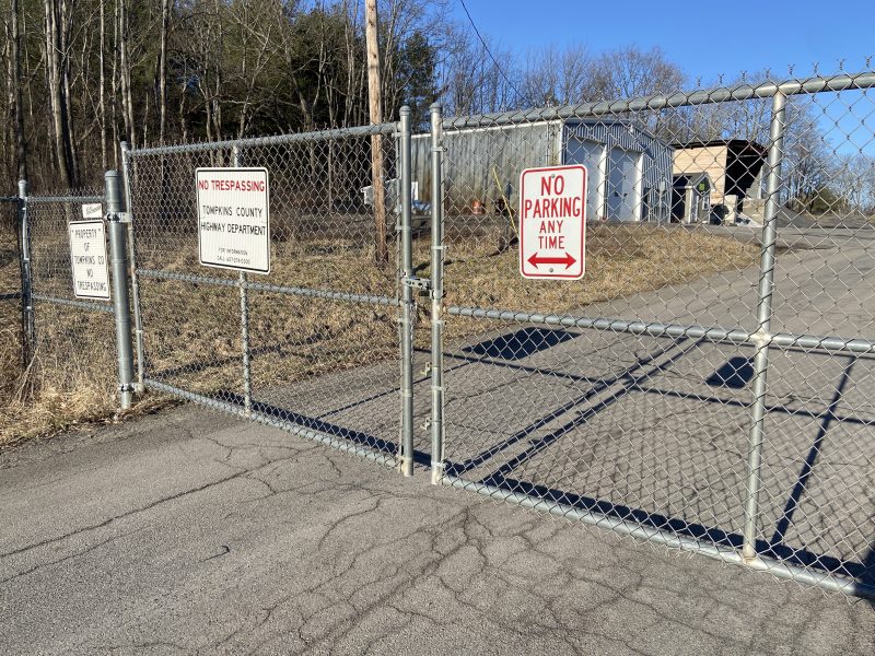 a closed gate at the front of an empty lot in Dryden