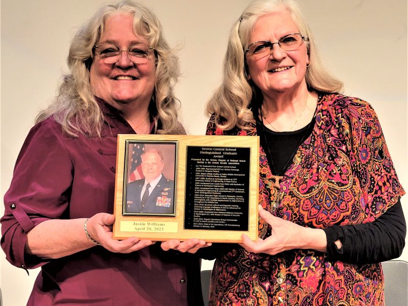 Barbara Lonsky (left) and Dolores Williams hold the plaque honoring Williams' son, Colonel Justin Williams, United States Air Force, who was inducted into the Groton High School Distinguished Graduate Hall of Fame at its annual ceremony on April 20.