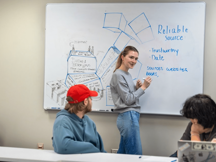 Isabelle Erskine '25, president of the TST-BOCES Career Skills Club, leads a discussion with a group of TST-BOCES students with intellectual disabilities and their teachers on March 17 in Kennedy Hall.