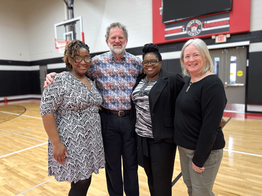 Photo by Jaime Cone Hughes 
Left to right: Gloria Coicou, Chief Engagement, Equity, & Grants Officer with Community Foundation of Tompkins County, George Ferrari, CEO of the Community Foundation, Leslyn McBean-Clairborne, director of Greater Ithaca Activities Center (GIAC), and Amy LeViere, chief philanthropic services & systems officer of Community Foundation, in the GIAC gymnasium earlier this year. 