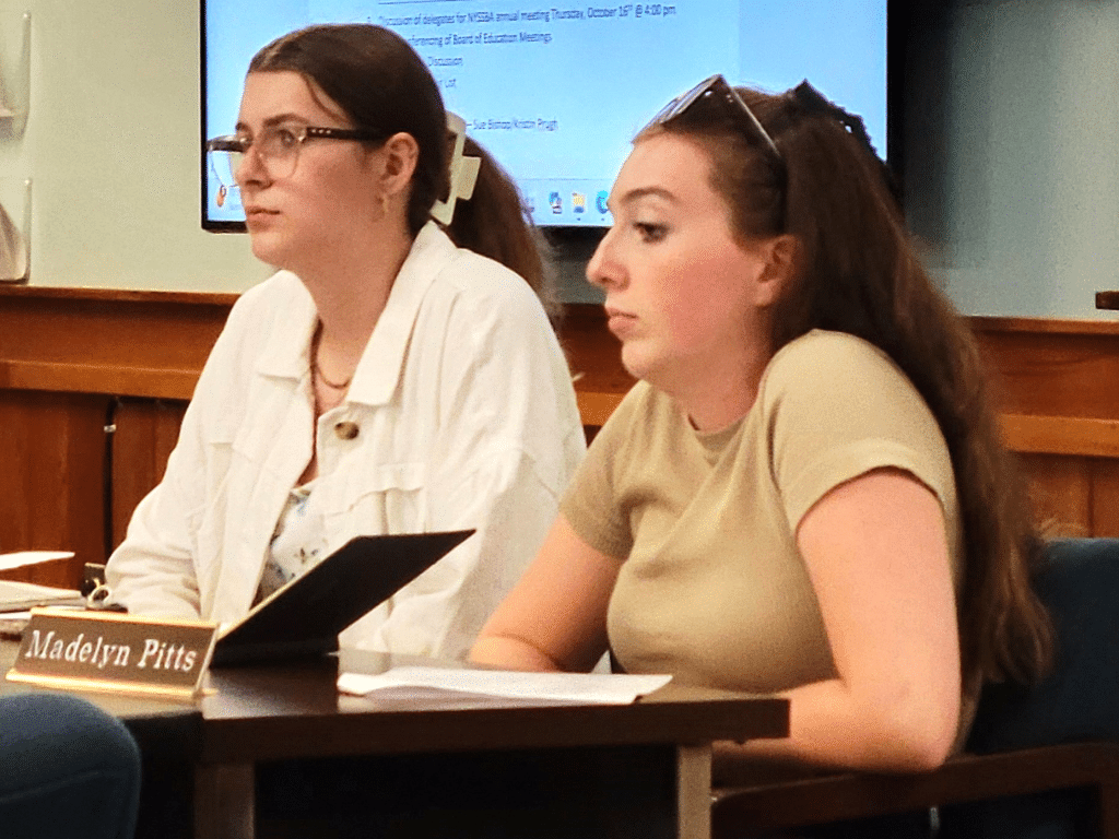 Photo by Linda Competillo
Grace Short (left) and Madelyn Pitts are seated at the board table for their first meeting as ex-officio members of the Groton Central School Board of Education. Pitts is the appointed member and Short is an alternate to ensure a student is always present for meetings in compliance with a new law requiring it. Although student board members will not have voting rights or access to executive sessions, their participation ensures student perspectives are represented in decision-making processes.
