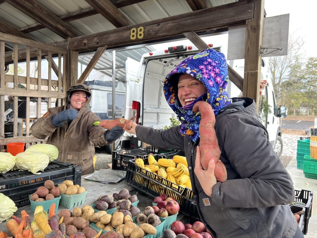 Photo by Jaime Cone Hughes 
Hannah Volpi (right), who often has a booth at the Ithaca Farmers Market as the owner of Foxi Flora, purchases produce from Ricky Connelly of West Haven Farm on her day off Nov. 23. 